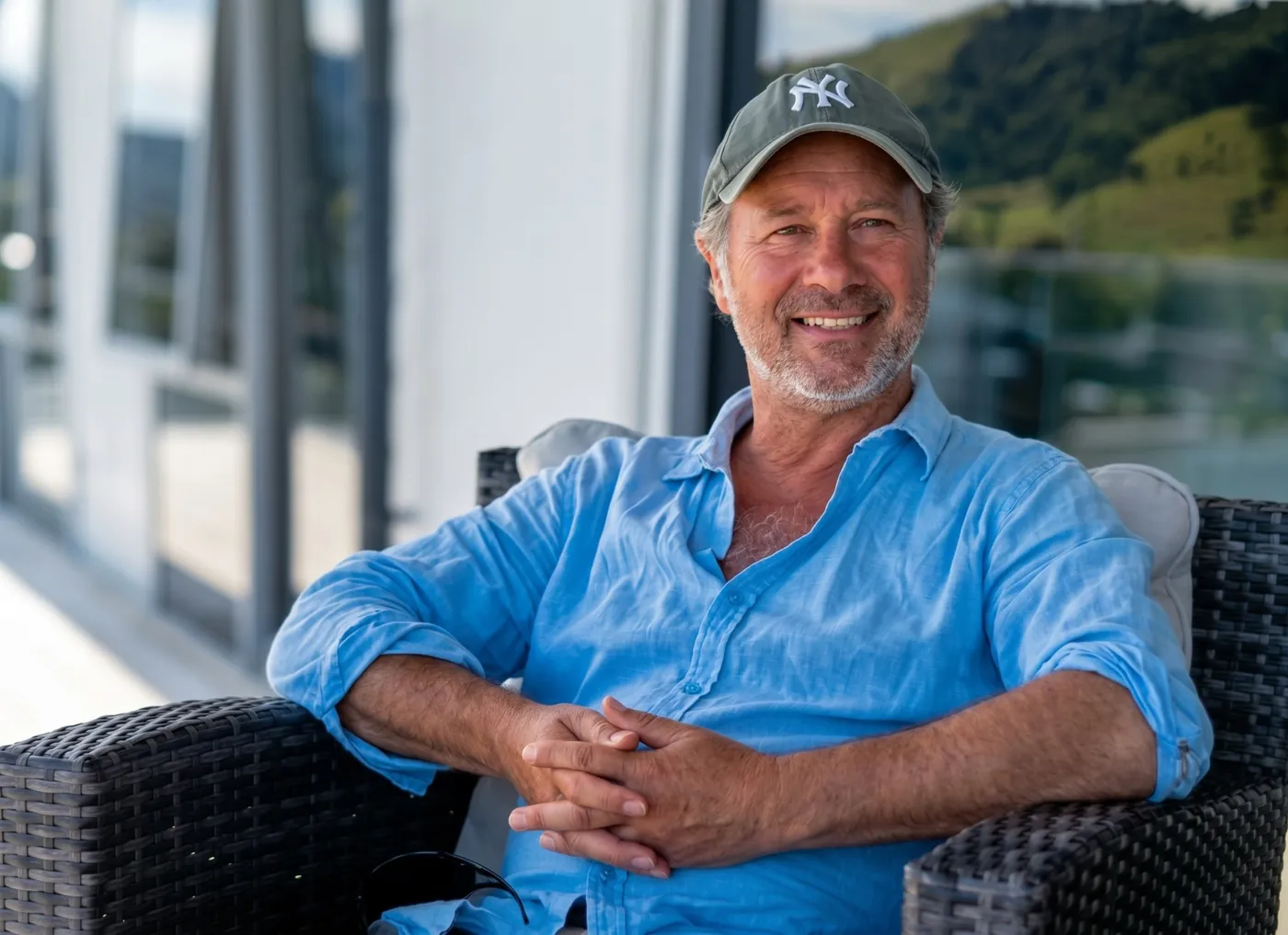 Steffen Lindner relaxing in a chair on a sunny terrace, smiling